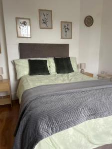 a large bed in a bedroom with a clock on the wall at Comfortable room in Newbridge