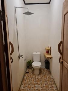 a bathroom with a toilet in a small room at Simagirau Homestay in Simpatdegat