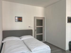 a bed in a room with white sheets at Apartman cheb in Cheb