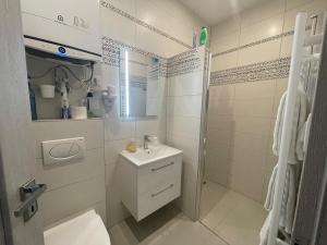 a white bathroom with a sink and a shower at Apartman cheb in Cheb