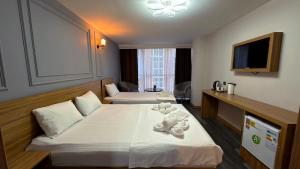 a hotel room with two beds with a teddy bear on it at Waves hotel in Avcılar