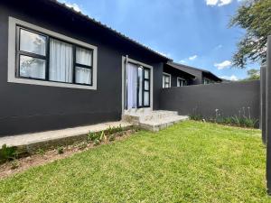 a black house with a lawn in front of it at Number 15 Jadde Apartments in Sandton