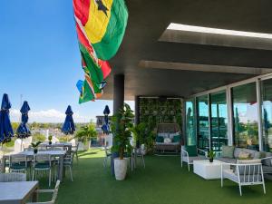 a patio with tables and chairs and a flag at Hotel Lunamar in Beira