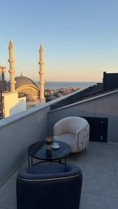 a balcony with a couch and a table on a roof at Waves hotel in Avcılar