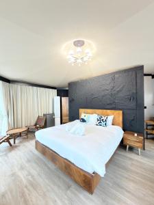 a bedroom with a large bed with a black wall at Umbrella tree v1 in Nathon