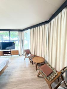 a room with chairs and a bed and a table at Umbrella tree v1 in Nathon