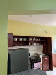 a kitchen with wooden cabinets and a stove top oven at sunset suswa apartment in Mombasa