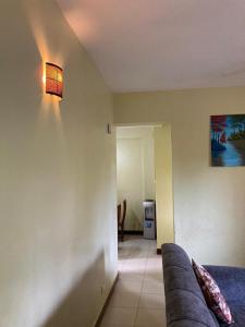 a living room with a couch and a light on the wall at sunset suswa apartment in Mombasa
