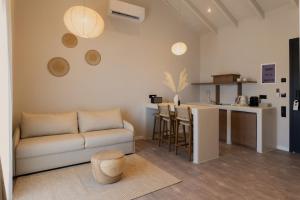 a living room with a couch and a kitchen at Ichos Boutique Apartments in Volissos