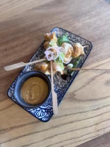 a plate of food with a bowl of dipping sauce at The Crown Aldbourne in Aldbourne