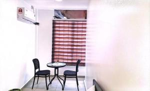 a small table and chairs in a room with a window at Hotel Lii View in Mersing
