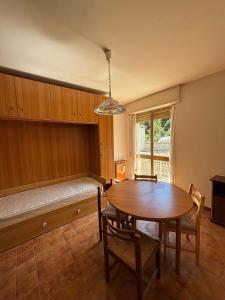 a dining room with a table and a bench with a window at Vecchio Mulino-Via Barale 40 in Entracque