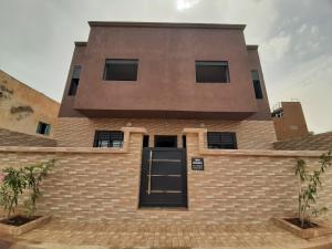 a large brick building with a black door at Résidence Maya 1 près de la plage in Ras El Ma