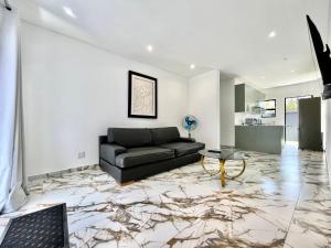 a living room with a black couch and a table at Number 15 Jadde Apartments in Sandton