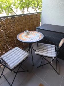 a table and two chairs and a table with a cup at Apartment with parking in the city center in Staré Mesto