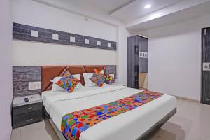 a bedroom with a large bed with a colorful blanket at FabHotel AGM in Ahmedabad