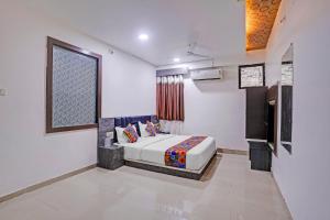 a bedroom with a bed and a window in it at FabHotel AGM in Ahmedabad