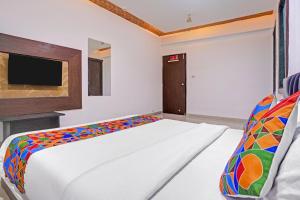a bedroom with a bed and a flat screen tv at FabHotel AGM in Ahmedabad