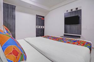 a bedroom with a bed and a flat screen tv at FabHotel AGM in Ahmedabad