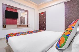 a bedroom with a bed and a flat screen tv at FabHotel AGM in Ahmedabad +24 photos