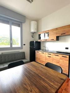 a kitchen with a table and chairs and a kitchen with a black refrigerator at Smart Living Tavernerio in Tavernerio +1 photo