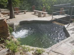 a pool of water with a picnic table and bench at Camping-Hotel Los Molinos in Ruidera