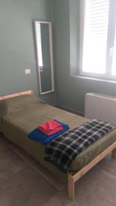 a bed sitting in a bedroom with a mirror at Ostello Postumia in Torre deʼ Picenardi