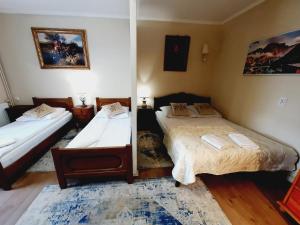 a bedroom with two beds and a mirror at Hotel i Apartamenty Rosa in Przemyśl