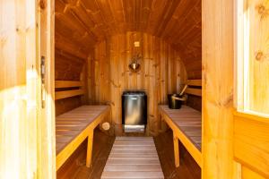 a small cabin with wooden walls and wooden benches at Villa Harmonia Private Jacuzzi and Pool Retreat near Rogaška in Rogatec