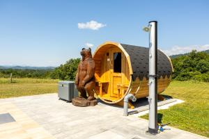 a bear statue standing in front of a tiny house at Villa Harmonia Private Jacuzzi and Pool Retreat near Rogaška in Rogatec