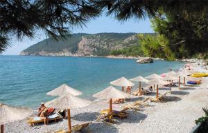 a beach with umbrellas and people sitting on the beach at Montebar1 in Bar