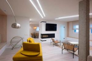 a living room with a yellow chair and a table at Kamiñone Landetxea in Beasain