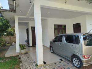 a silver minivan parked in front of a house at Bosadi Hotel katunayake in Katunayaka