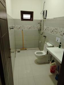 a bathroom with a toilet and a sink and a phone at Bosadi Hotel katunayake in Katunayaka