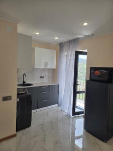 a kitchen with white cabinets and a large window at hyuratun Shamlugh in Shamlugh
