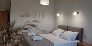 a bedroom with a bed with white sheets and pillows at ZOGRAFOS SPIROS Rooms in Pérdika