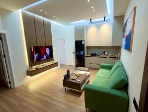 a living room with a green couch and a table at Apt Elite in Khujand