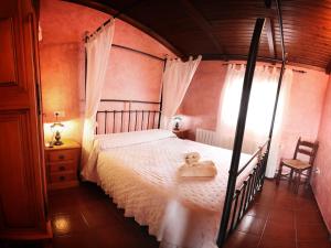 a bedroom with a bed with a white bedspread at La Casa de los Templarios in Puebla de Alcocer
