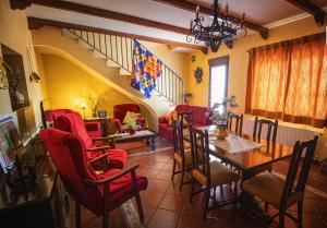 a living room with a table and red chairs at La Casa de los Templarios in Puebla de Alcocer