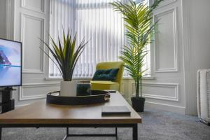 a living room with a chair and two plants at Spacious 4BR retreat Eden Vale by Stay With Us in Sunderland
