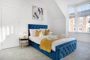 a blue bed in a white room with a window at Spacious 4BR retreat Eden Vale by Stay With Us in Sunderland