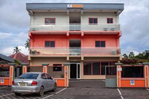 a building with a car parked in front of it at Barolena Hotel en appartement in Paramaribo