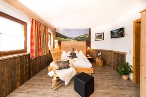 a bedroom with two beds and a large window at Hotel Astrid mit Panoramapool & inklusive JokerCard in Saalbach-Hinterglemm
