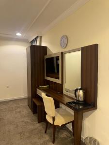 a room with a desk with a television and a mirror at فندق شعاع النزهة - مكة المكرمة in Mecca