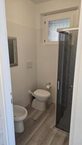 a bathroom with a toilet and a glass shower at Bella Vita Stays Wellness in Sondrio