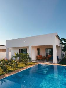 a swimming pool in front of a villa at Diani Dream luxury apartment in Diani Beach