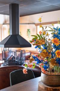 a vase filled with flowers sitting on a table at Koning te Rijk - Residence de Eese in De Bult