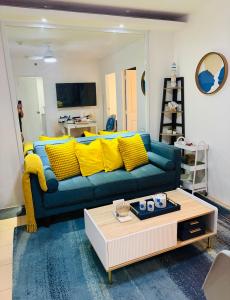 a living room with a blue couch and yellow pillows at Bienvenida Condotel in Dumaguete
