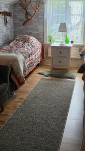 a bedroom with a bed and a table with a lamp at Kolmårdstorpet Blomsätter in Kolmården