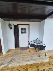 a patio with a table and chairs on a wooden floor at Cozy Home in Stokmarknes +7 photos